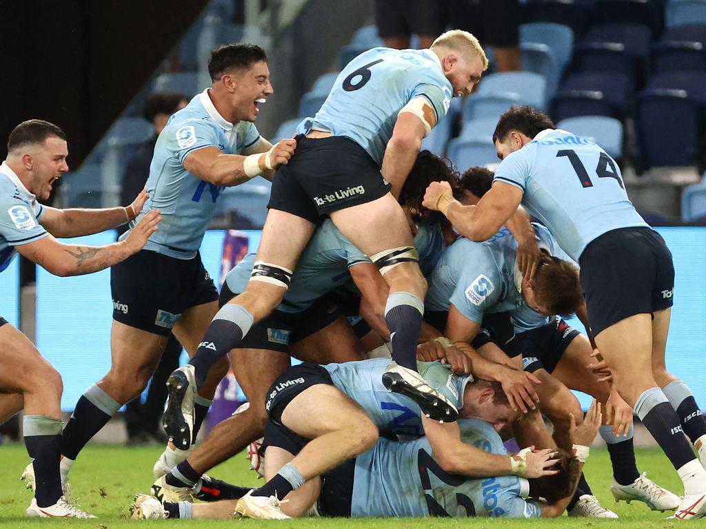 Waratahs players celebrate teammate Will Harrison kicking a drop goal to beat the Crusaders. Picture: AFP