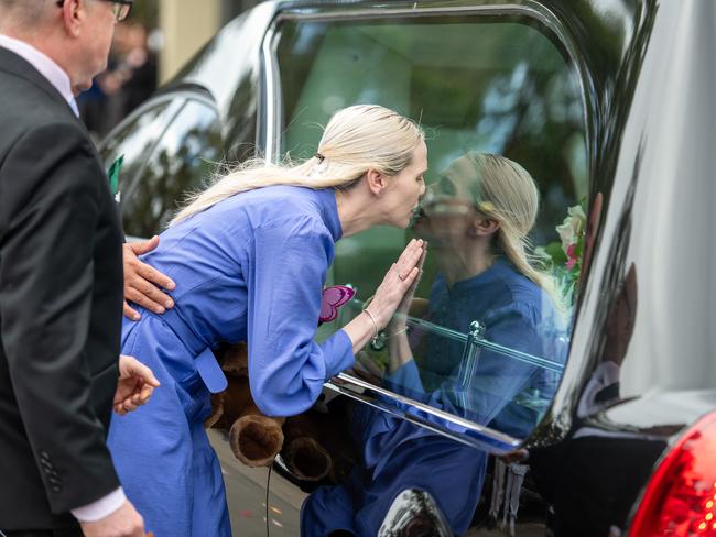 Heartbreaking... Charlotte’s mum kisses the hearse carrying her daughter. Picture Thomas Lisson