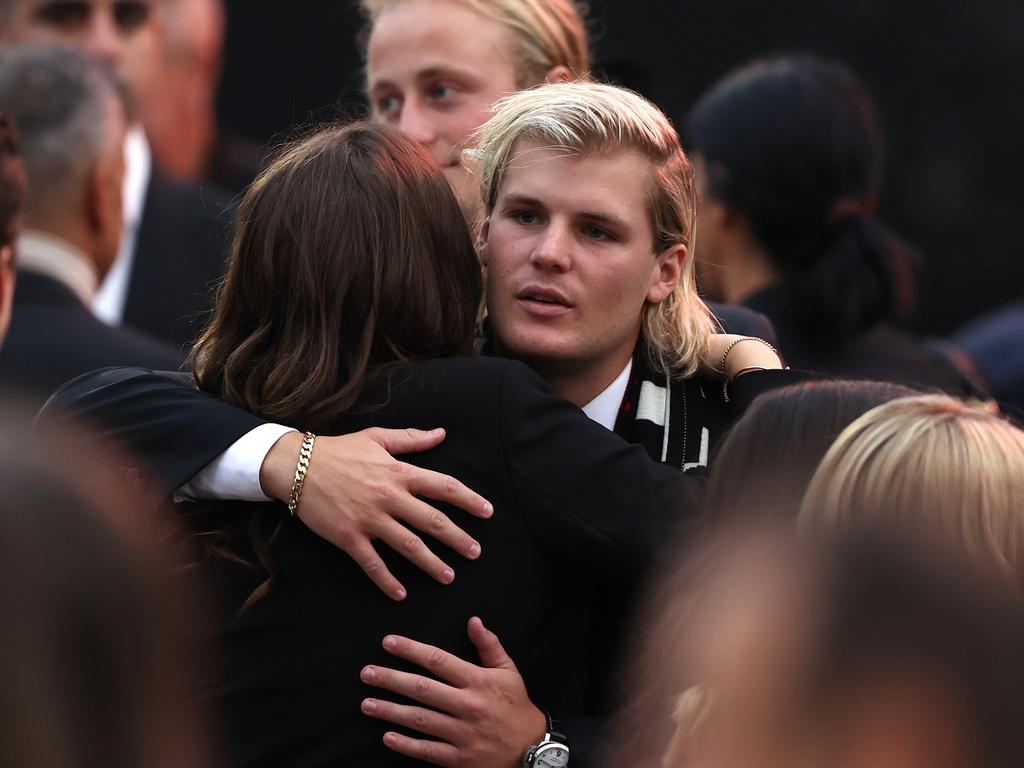 Jackson Warne hugs family and friends during the state memorial service for his father. Picture: Getty Images