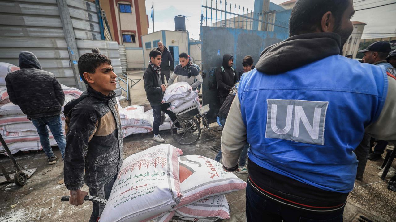 Displaced Palestinians receive food aid at the United Nations Relief and Works Agency for Palestine Refugees (UNRWA) centre in Rafah in January. Human rights groups say Israel has blocked aid. Picture: AFP