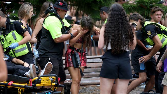 A young girl is helped by paramedics as another reveller (left) is stretchered away. Picture: Damian Shaw