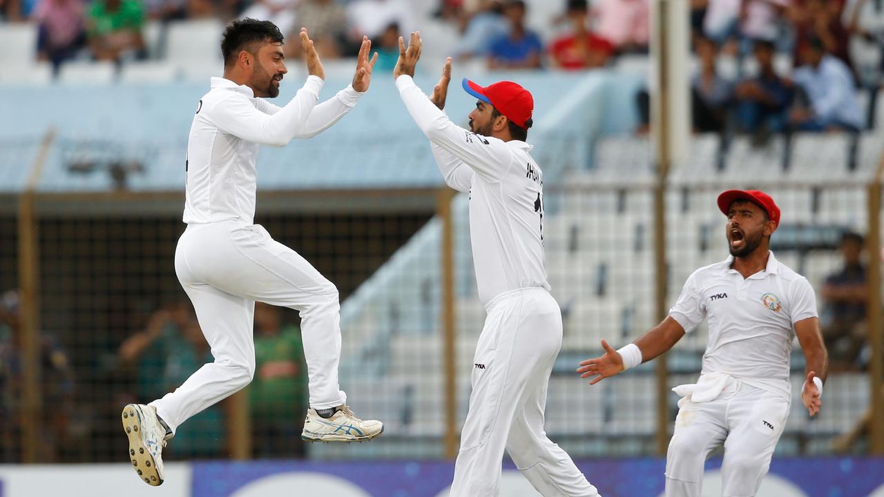 Afghanistan cricketer Rashid Khan celebrates with his teammates. Photo by STR / AFP