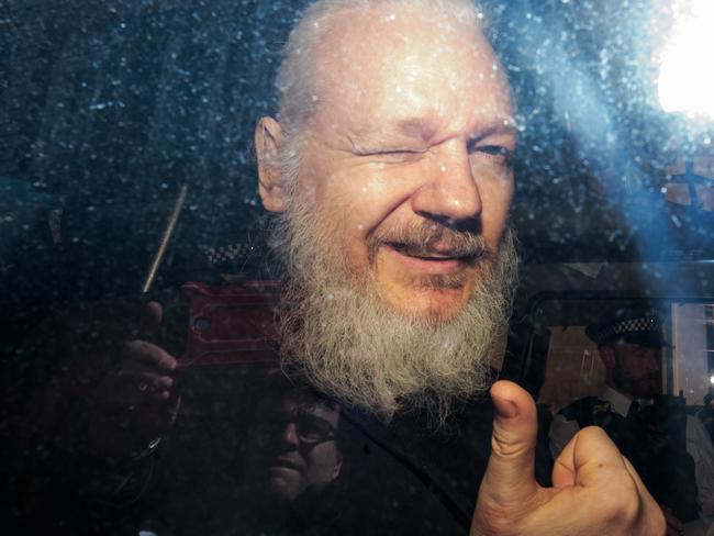 ulian Assange gestures to the media from a police vehicle on his arrival at Westminster Magistrates court in London, England. Picture: Getty Images