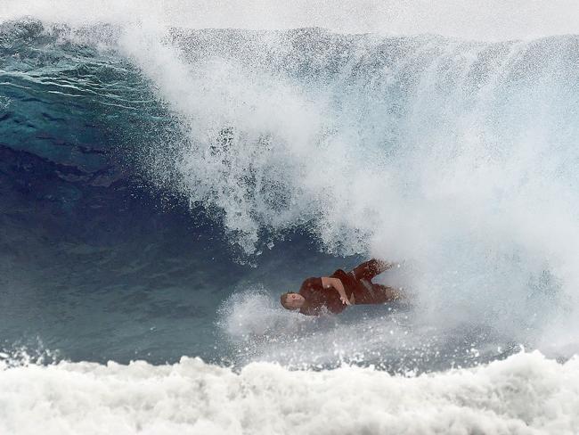 A surfer falls from his board at Snapper Rocks on the Gold Coast , Thursday February 21, 2019. Huge swells and high tides are set to pummelling south-east Queensland beaches over the coming days as Cyclone Oma tracks towards the Queensland coast. (AAP Image/Dave Hunt)