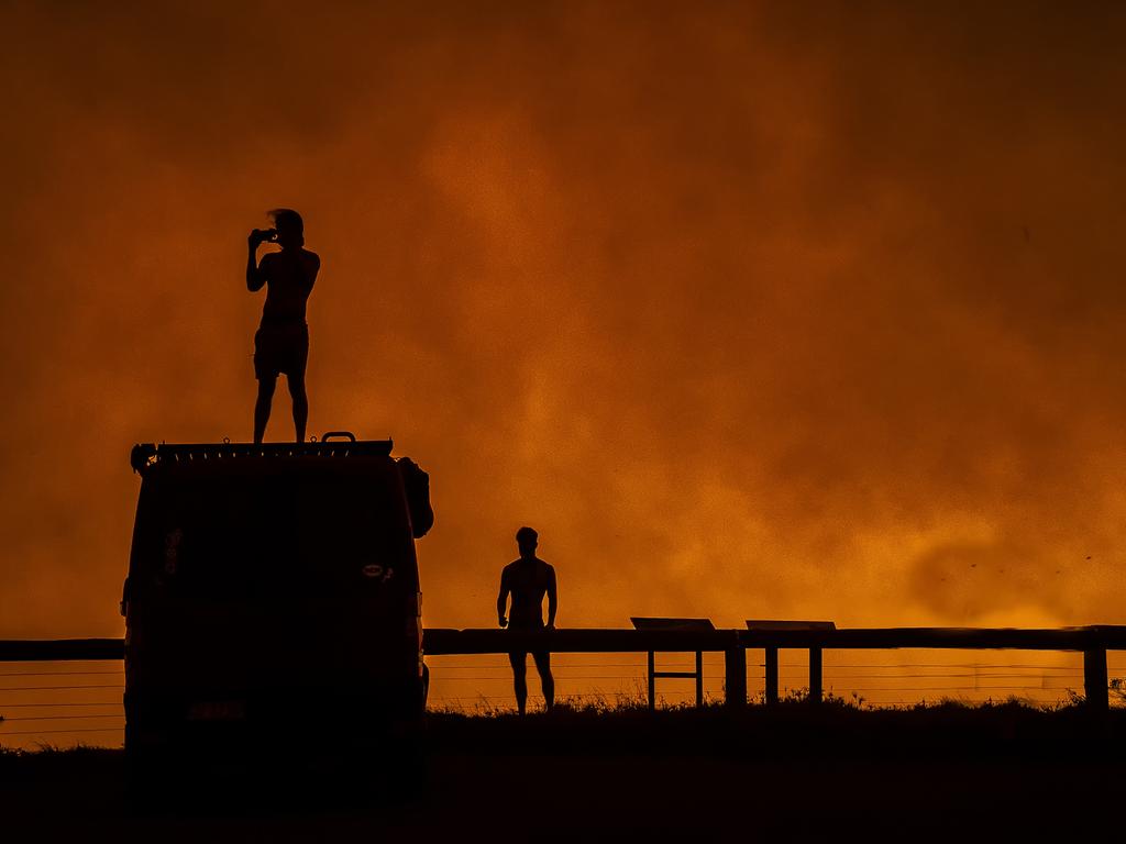 A summer of horror and heroes ... one of the photos by members of the public included in Fighting Spirit. Flames illuminate Tomakin Headland in NSW, January 2020. Picture by David Wallace.