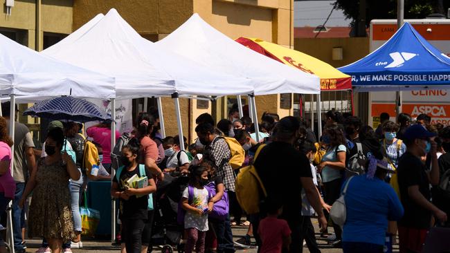 Families attend a back to school event offering school supplies, Covid-19 vaccinations, face masks, and other resources in Los Angeles. Picture: AFP