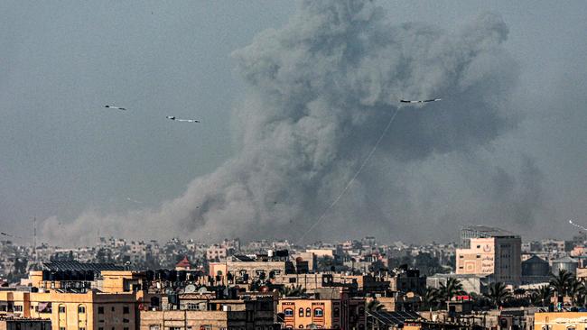 Kites fly in Rafah as a smoke plume erupts during Israeli bombardment on Khan Younis in the southern Gaza Strip on March 29. Picture: AFP