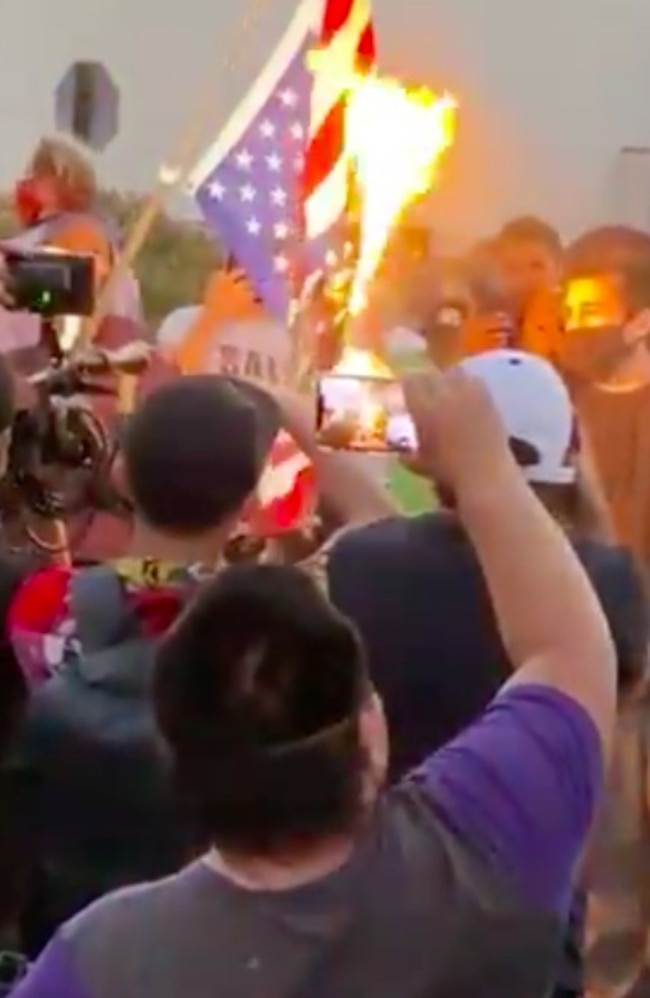 Protesters burn the American flag at a rally in Downtown Los Angeles. Picture: Veronica Miracle