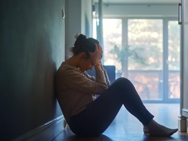 istock generic:  woman, abuse, DV, domestic violence, harassment, sexual harassment.   Sad Young Woman Sitting on the Floor In the Hallway of Her Appartment, Covering Face with Hands. Atmosphere of Depression, Trouble in Relationship, Death in the Family. Dramatic Bad News Moment . Picture: istock