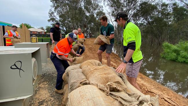 Residents and council workers chip in to protect their township. Picture: Angelica Snowden