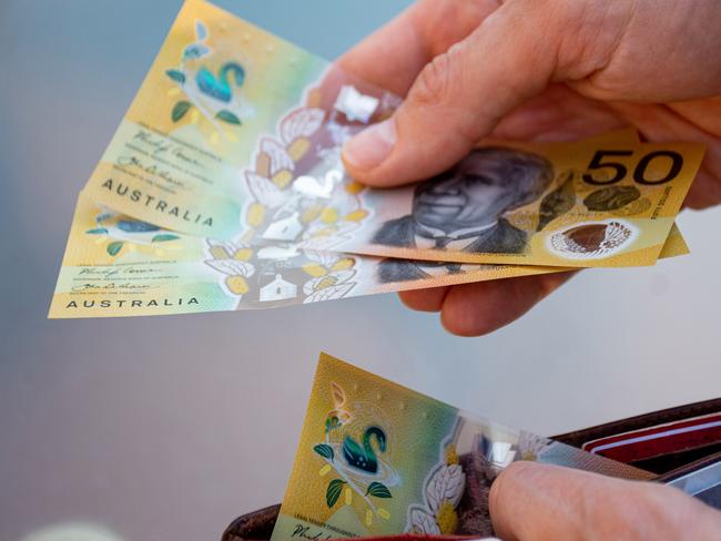 Hands holding wallet with australian dollars and make a payment - coronavirus finance struggle concept