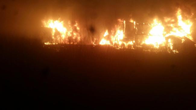 The scene that confronted the hero truck driver about 11.20pm in the first crash at Granite Creek. This was taken moments before he pulled a man free from the wreckage of his burning rig.