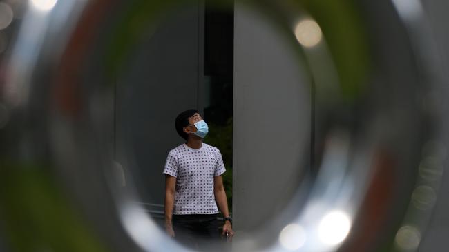 A man wearing a face mask as a preventive measure against the spread of the COVID-19 coronavirus walks in the Raffles Place financial business district in Singapore. Picture: AFP