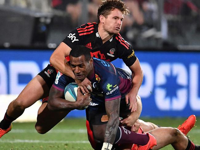 Redâs Suliasi Vunivalu (C) is tackled during the Super Rugby Pacific quarterfinal match between the Canterbury Crusaders and Queensland Reds at Orangetheory Stadium in Christchurch on June 3, 2022. (Photo by Sanka Vidanagama / AFP)