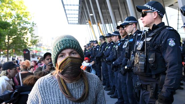 A masked protester is seen outside the Melbourne Exhibition and Convention Centre.