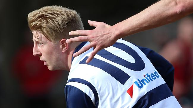 Jake Kalanj dishes off a handball. Picture: Hamish Blair