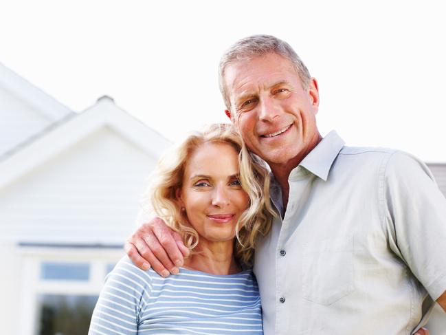 Portrait of a happy senior man with a mature woman in front of their house. Attractive older couple istock