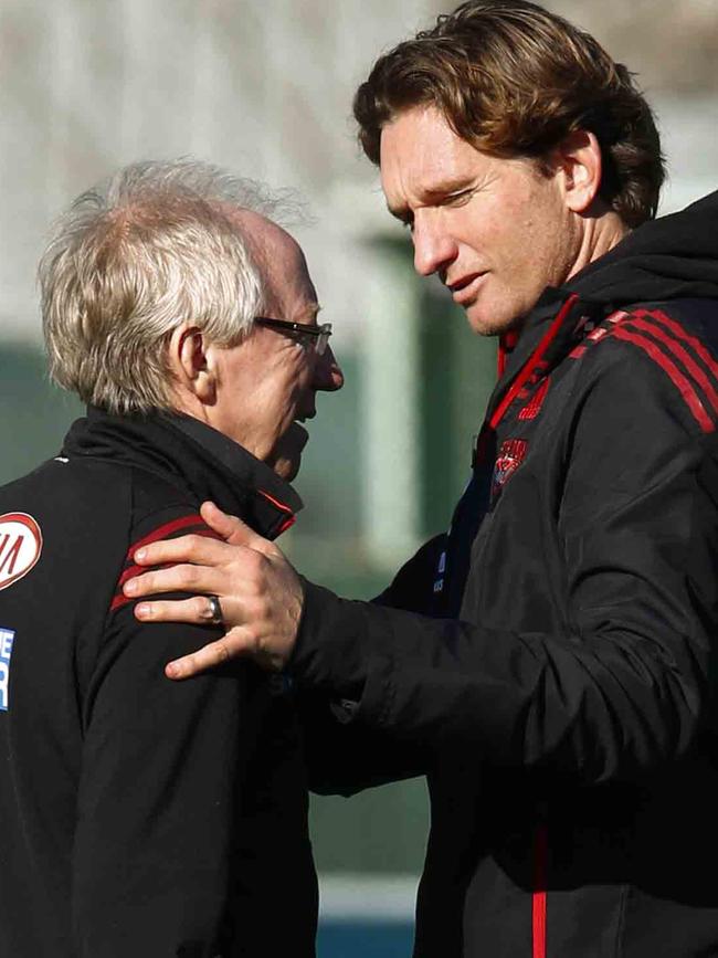 James Hird puts an arm around Bruce Reid at training in 2013.