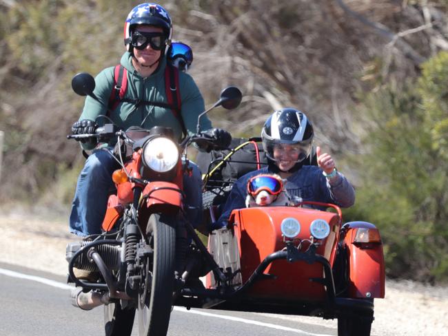 L-R Nathan Coleman with dog Buddy strapped to his back, and in the sidecar, Ashleigh Coleman with dog Callie, riding in their Ural sidecar in country SA. Photo: Supplied