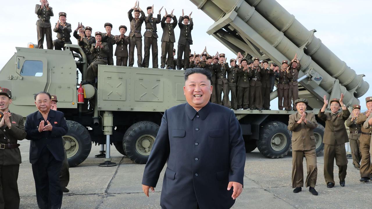 A picture released of North Korean leader Kim Jong-un (centre) celebrating the test-firing of a ‘newly developed super-large multiple rocket launcher’ at an undisclosed location in 2019. Picture: KCNA via KNS/AFP