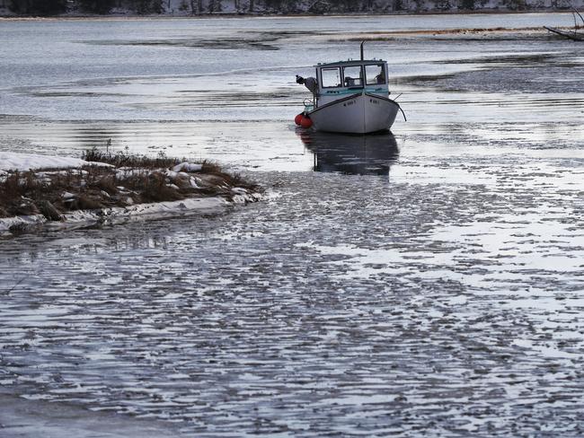 A fishing boat makes its way through a slushy river in Maine.