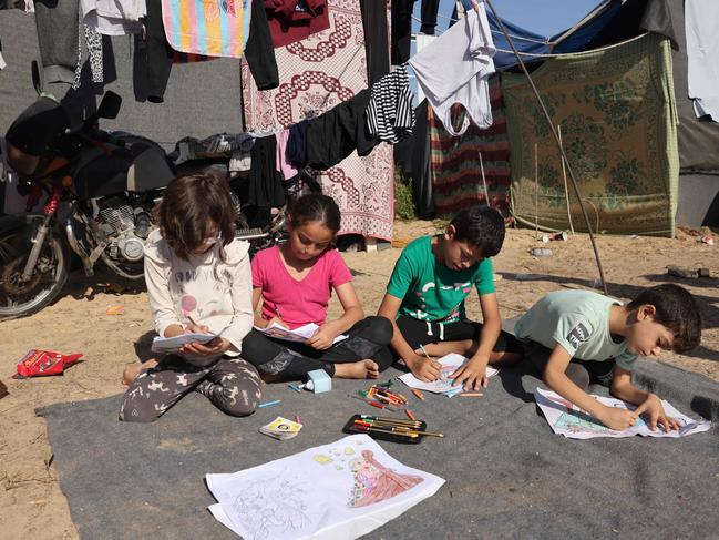 Displaced Palestinian children draw and colour in at a centre set up by the UN. Picture: AFP