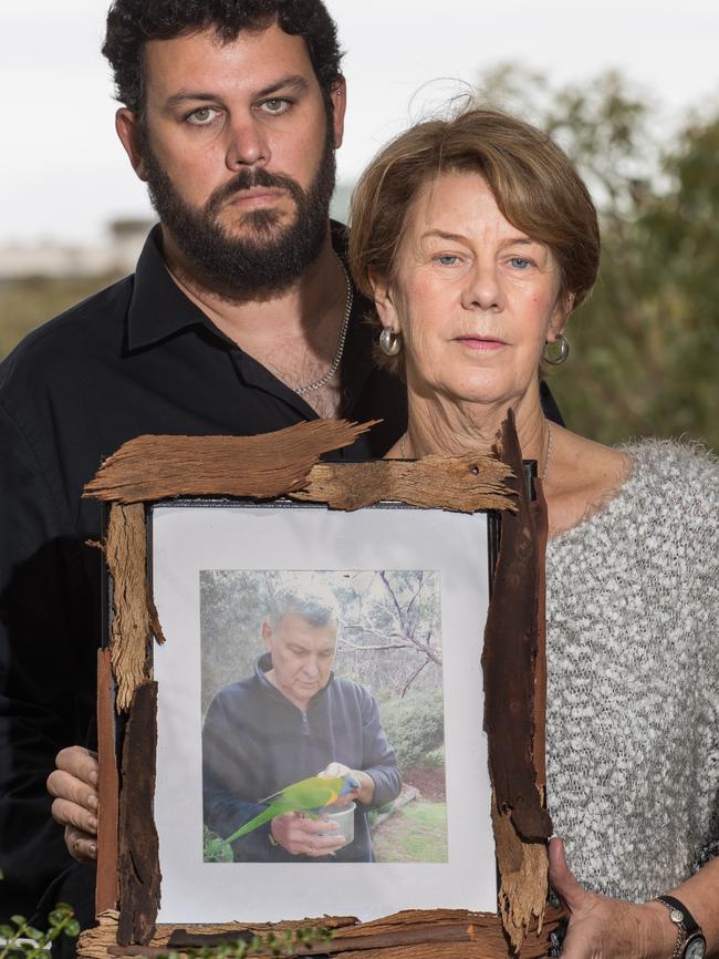 Clive and Barb Spriggs in their family home in Bellevue Heights with a photo of father and husband Bob Spriggs who was mistreated at Oakden. Picture: Matt Loxton