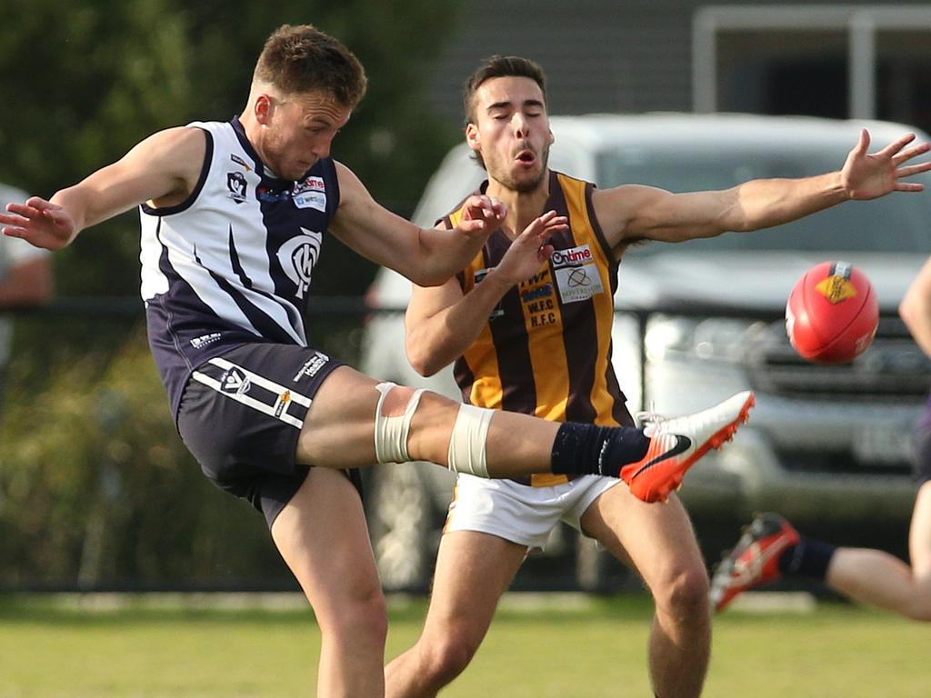 RDFL: Milan Savic of Melton Centrals gets his kick away under pressure. Picture: Hamish Blair