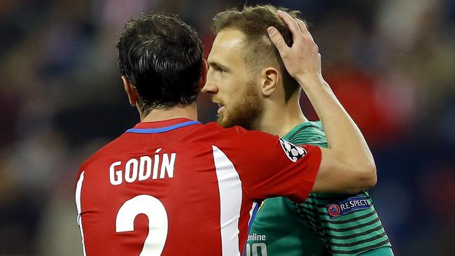 Atletico's Diego Godin, left, embraces Atletico goalkeeper Jan Oblak.