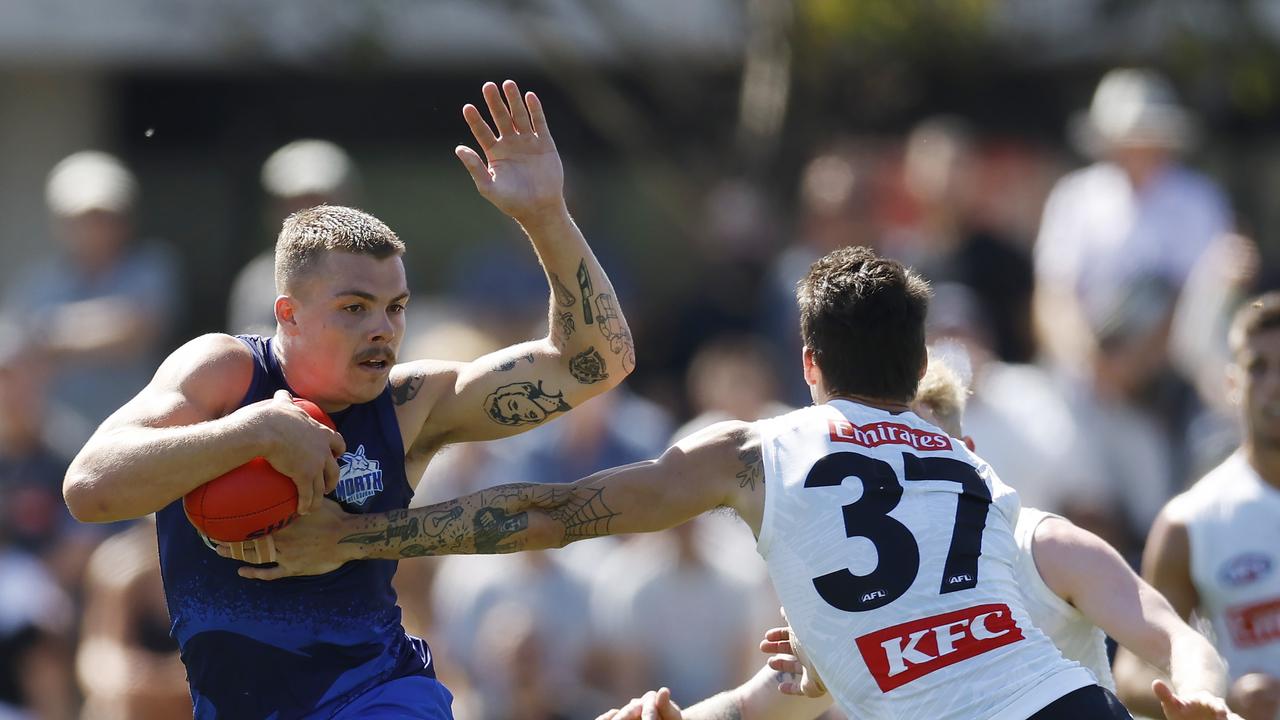 Cameron Zurhaar of the Kangaroos charges past Oleg Markov of the Magpies. Picture: Michael Klein