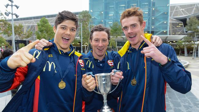 Tom Lewis, coach Tony Bamford and Jez McLennan at Adelaide Airport after they beat Victoria to secure the state's first under-18 national title since 2014. Picture: AAP/Brenton Edwards