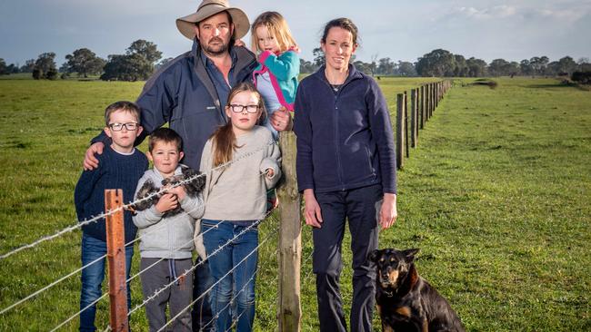 The Law family Jason and Claire with Emma, 2, Grace, 9, George, 7 and Jojo, 6, and dogs Neil and Archie on their property where the fence runs along the SA-VIC border. Picture: Jake Nowakowski