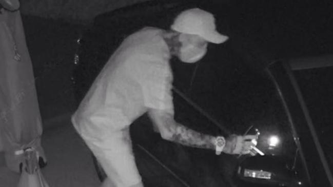 A heavily tattooed male wearing Nike shoes beside a car suspected to be stolen. Picture: I SPY security