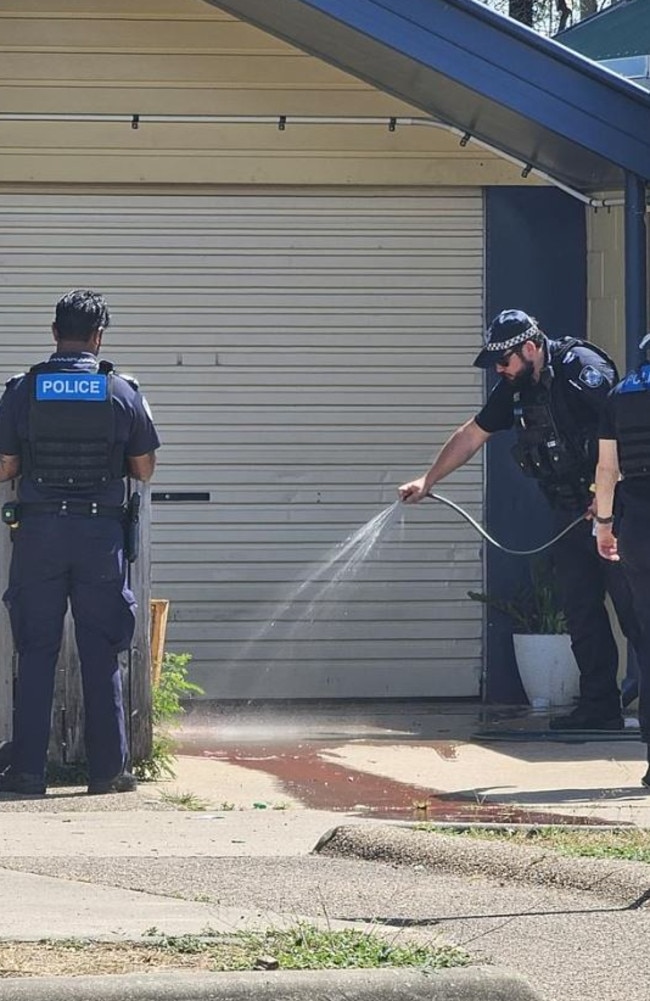 Police hose blood off the driveway of Annmarie’s Garbutt residence after she had her arm severed by her dog. Picture: Natasha Emeck