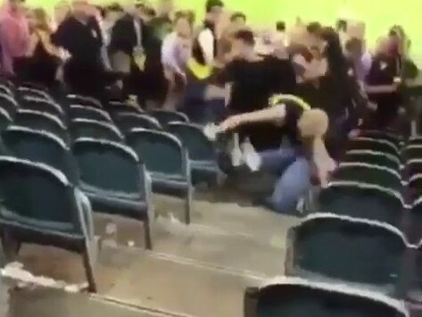 Shocked fans watch on as a brawl erupts after the game.