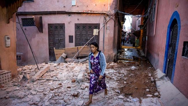 A woman walks through the rubble past earthquake-damaged houses in the old city in Marrakesh. Picture: AFP