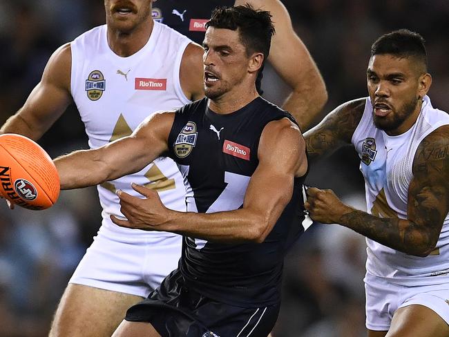 MELBOURNE, AUSTRALIA - FEBRUARY 28: Scott Pendlebury of Victoria kicks whilst being tackled during the AFL Bushfire Relief State of Origin match between Victoria and the All Stars at Marvel Stadium on February 28, 2020 in Melbourne, Australia. (Photo by Quinn Rooney/Getty Images)