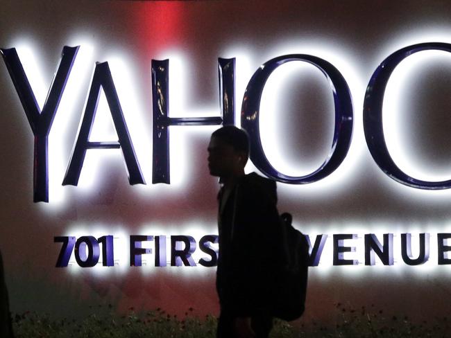 FILE - In this Nov. 5, 2014, file photo, a person walks in front of a Yahoo sign at the company's headquarters in Sunnyvale, Calif. Yahoo announced Wednesday, March 2, 2016, that the company is adding a new component to its Sports vertical: competitive video gaming. Yahoo said that Esports will offer video coverage of live tournaments, including expert commentary and interviews with top players. Esports will also include articles, scores, team rosters, schedules, player rankings, calendars and statistics. (AP Photo/Marcio Jose Sanchez, File)