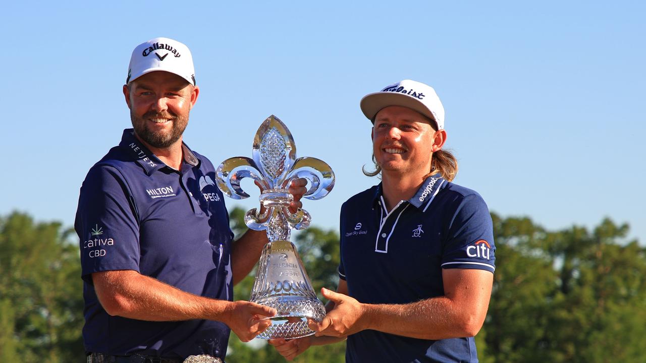 Marc Leishman and Cameron Smith of Australia pose with the trophy after winning in a playoff hole during the final round of the Zurich Classic of New Orleans at TPC Louisiana.