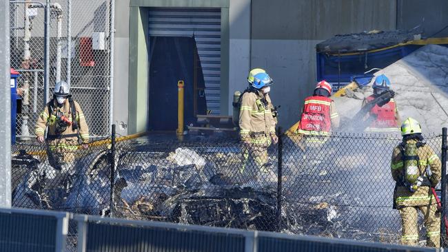 Firefighters sift through the wreckage. Picture: Jason Edwards