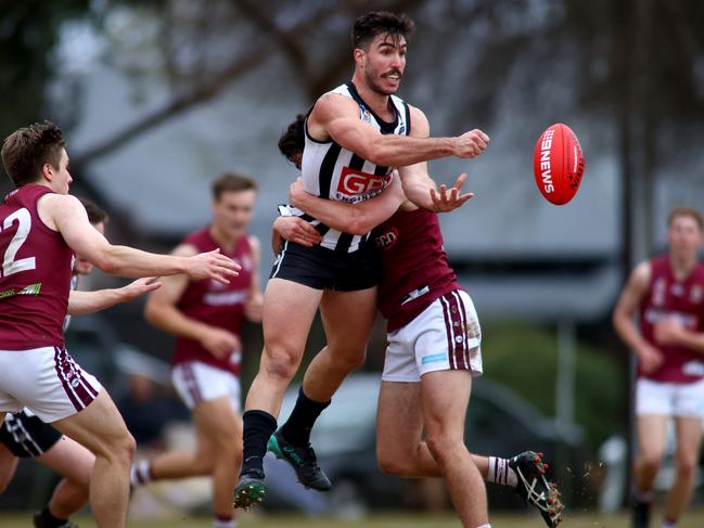 Jonathan Giannini of Payneham Norwood Union hand balls the ball away in the tackle. Footy league division one - Payneham Norwood Union v Price Alfred Old Collegians at Payneham Oval. Photo Kelly Barnes