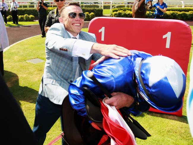 Trainer Chris Munce gives jockey Jim Byrne a friendly whack after he piloted Nicconi Leggera to victory in the Cascade QTIS Two-Years-Old Handicap. Picture: Claudia Baxter