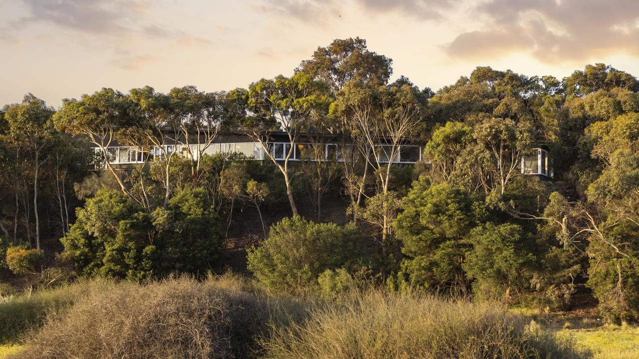 The long, dark-coloured house was designed to integrate with its surrounding environment.