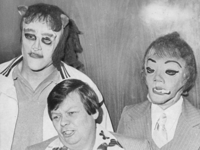 This 1979 photo shows transgender man Dante "Tex" Gill, flanked by masked Frank Cocchiara, left, and Donna Potts while leaving the Public Safety Building in Pittsburgh. Picture: AP