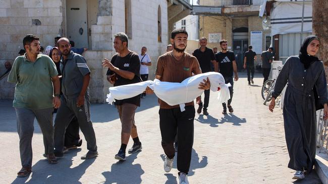 A relative carries the shrouded body of 10-year-old Sama al-Debs, who was killed during an Israeli army operation in the Jabalia refugee camp in the central Gaza Strip. Picture: Omar Al-Aattaa / AFP