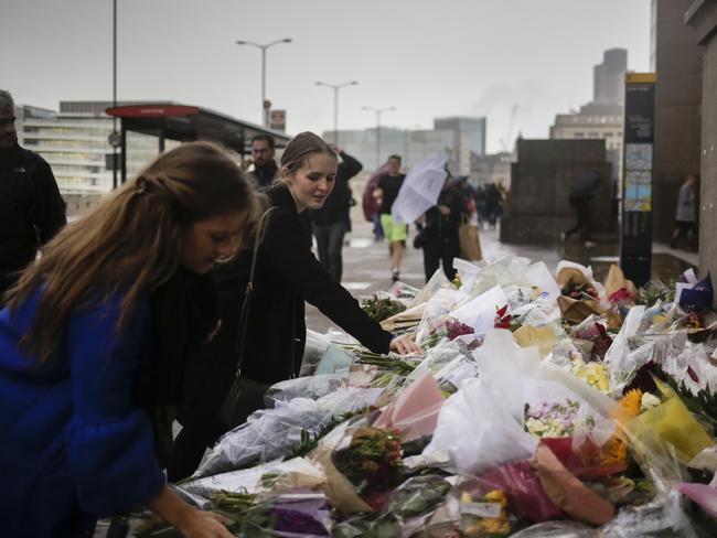 Women place bouquets of flowers on a memorial for victims at London Bridge. Picture: AP