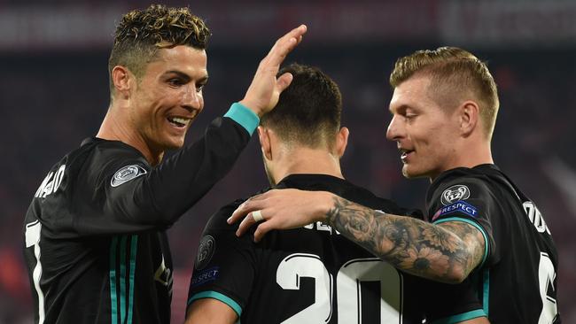 Real Madrid's Spanish midfielder Marco Asensio (C) celebrates with Cristiano Ronaldo (L) and Toni Kroos after scoring a goal