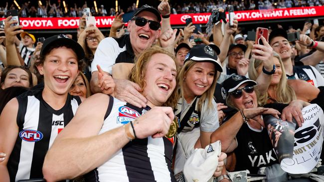 McCreery celebrates with the crowd before embracing Julie in the rooms. Picture: Dylan Burns/AFL Photos