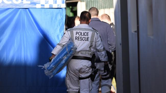 Officers take the tarpaulin into the Surry Hills property. Picture: Darren Leigh Roberts