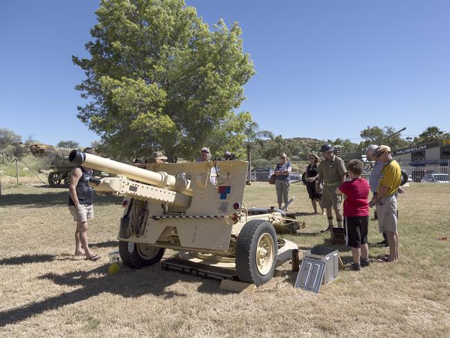 People gather around the 25lb gun used to acknowledge the first bombing on Darwin at the RSL commemoration service. PICTURE: Christine Ansorge